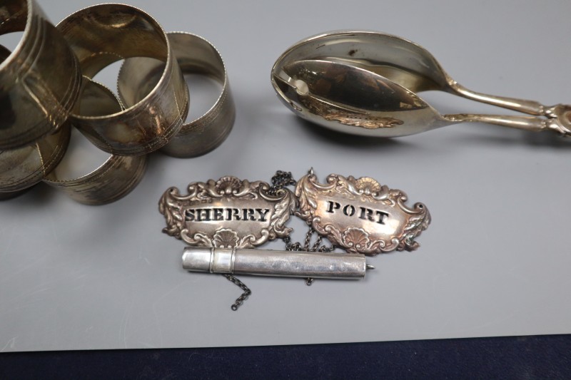 A pair of Victorian silver wine labels, pair of silver salad servers, pencil holder and six plated napkin rings.